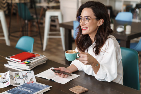 Attractive young brunette woman using mobile phone
