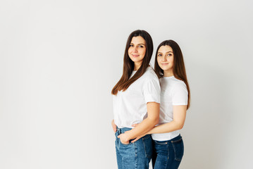 Naklejka premium Beautiful two brunette girls in white t-shirts