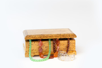 Jasper, agate and nephritis beads in wooden jewelry box and silver bracelet isolated on white background