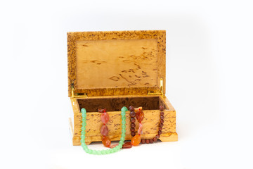 Jasper, agate and nephritis beads in wooden jewelry box isolated on white background