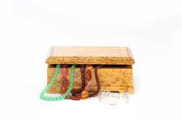Jasper, agate and nephritis beads in wooden jewelry box and silver bracelet isolated on white background