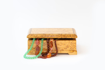Jasper, agate and nephritis beads in wooden jewelry box isolated on white background