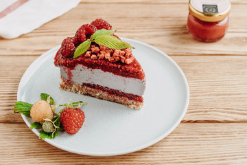 Raw dessert. Cake with berries and nuts, on a wooden background