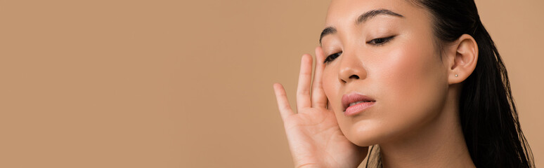 beautiful asian girl touching face isolated on beige, panoramic shot - obrazy, fototapety, plakaty