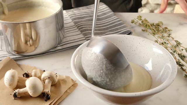 Healthy eating, serving mushroom soup in a bowl. Eating creamy and rustic white soup with mushroom
