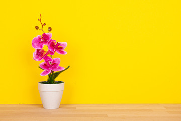 Kunstblume auf gelbem Hintergrund mit Textfreiraum