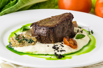 Grilled lamb carre with warm couscous salad, roasted vegetables, Dijon mustard and red wine sauce