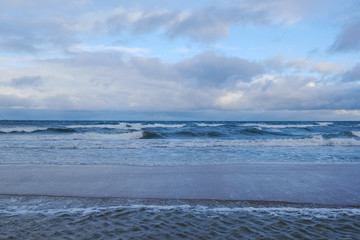 Sea shore with waves flooding the sand and creating interesting patterns. Baltic Sea, Dziwnowek, Poland