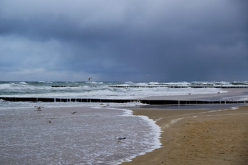 Waves crashing against a breakwater on a stormy day on the beach in Dziwnowek / Poland on the Baltic Sea