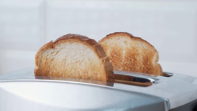 Preparing bread in toaster in the kitchen