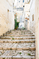 Fototapeta na wymiar Small street with cobblestone stairs in Unesco town Matera, Italy 