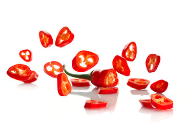 Chili pepper and its slices close-up falling