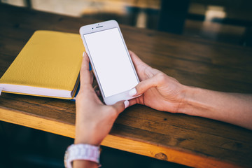 Cropped image of female blogger using smartphone device with copy space area for internet advertising for online web messaging, selective focus on modern phablet technology with mock up screen