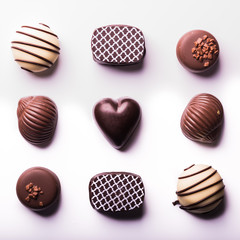  Nine delicious chocolate bonbons forming a square on a white background. Square format.