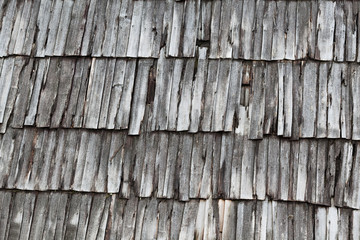 Roof covering from old low quality gray wooden boards overlapped and parallel fastens to hobnail and spike