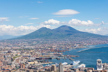 Aerial view of Naples from the Castel Sant'elmo. You can see  in the background the city's port and the Vesuvius. There are houses and buildings.