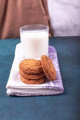 Cup of milk with biscuits on tablecloth