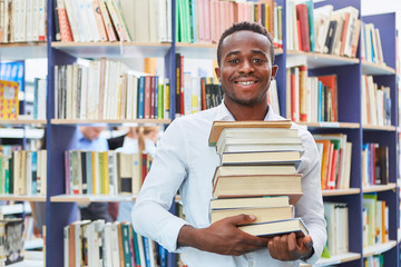 Afrikanischer Mann mit einem Stapel Bücher