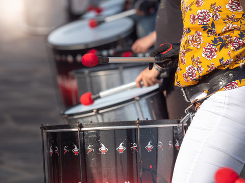 Closeup image of street musicians playing on drums with drumsticks during street preformance