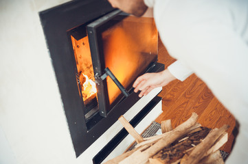 Man puts dry firewood in fireplace