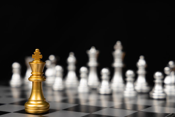 Glod king stay alone on chess board on a black background with business strategy planning ideas and connect to business information concept.