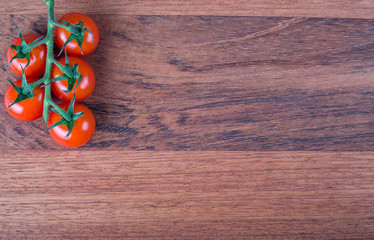 red tomato branch on wood background