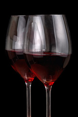 two glasses with red wine isolated on black