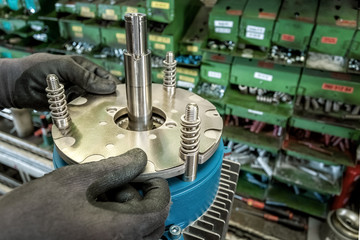 Skilled industrial worker assembling electric motor, detail
