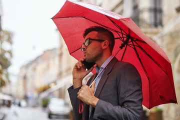 stylish businessman talking on the phone on the street