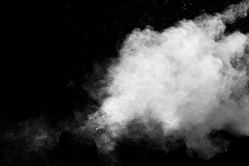 Freeze motion of white dust particles splash on black background.White powder explosion clouds.