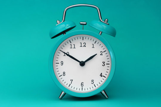 Modern alarm clock turquoise closeup object. Time online system concept