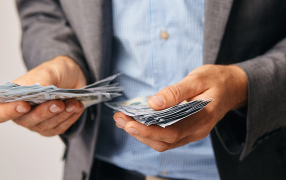 a closeup of hands of a man who remits money