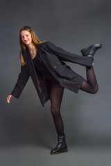 growth portrait of a young girl in a bodysuit and tights on a gray background
