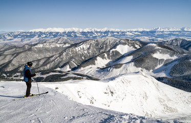 Fototapeta na wymiar Skier freerider on top of the snowy hill