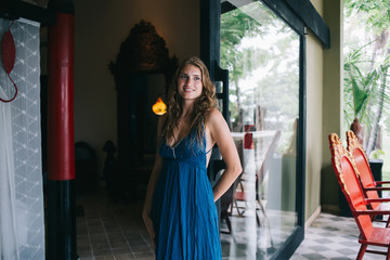 Cheerful young woman standing on tropical terrace