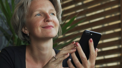Fototapeta premium Close up attractive gray hair lady female using smartphone in cafe