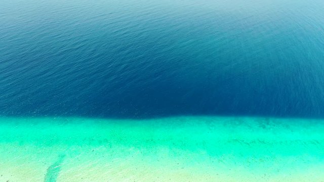 Aerial tropical abstract background. Tupai Heart Island Coral Reef Atoll In French Polynesia, Beautiful deep blue ocean meets turquoise shallow water