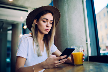 Young lady enjoying juice and browsing social media