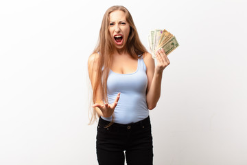 yound blonde woman looking angry, annoyed and frustrated screaming wtf or what‚Äôs wrong with...