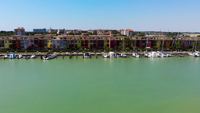 Porto Santa Margherita marina with colorful beach homes in Caorle Italy, Aerial drone flyover shot
