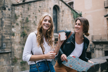 Smiling women visiting old town and having coffee