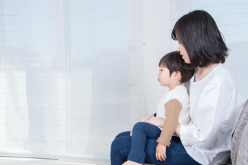 Obraz premium リビングのソファに座る母親と子供