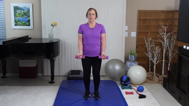 Sandra does bicep curls to work the arms.
