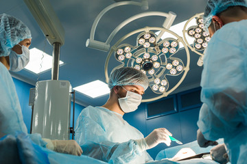 An international team of doctors performs a complex surgical operation on a patient under...