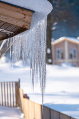 Icicles hang from the snowy roof of a mountain cottage