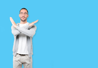 Young man making a gesture of not crossing with the arms