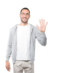 Young man making a number five gesture