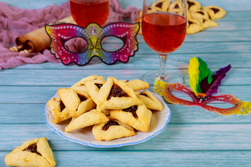 Hamantashen cookies with mask, wine and megillah papyrus roll.