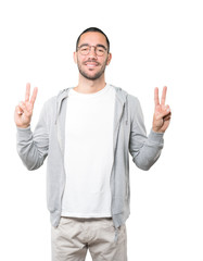 Happy young man making a victory gesture with his fingers