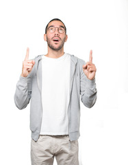 Fototapeta premium Amazed young man pointing up with his finger